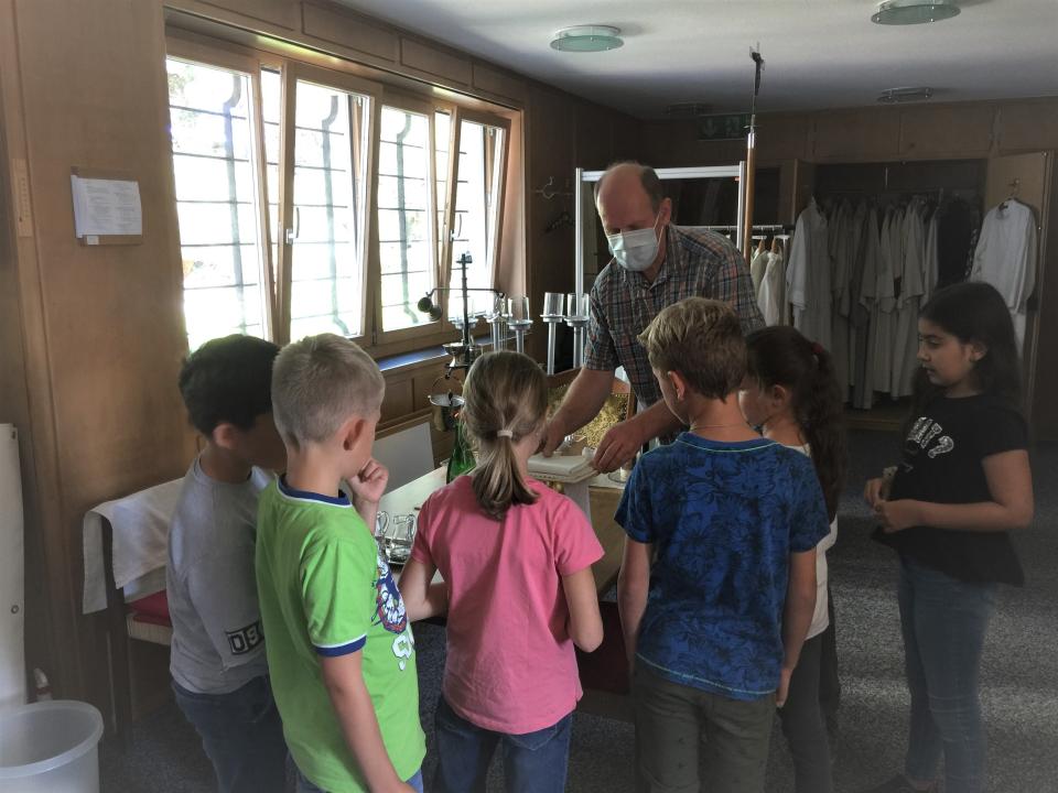 Mesmer Beat Köpfli zeigt den Kindern die Paramente, welche im Gottesdienst auf dem Altar stehen.