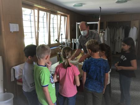 Mesmer Beat Köpfli zeigt den Kindern die Paramente, welche im Gottesdienst auf dem Altar stehen.